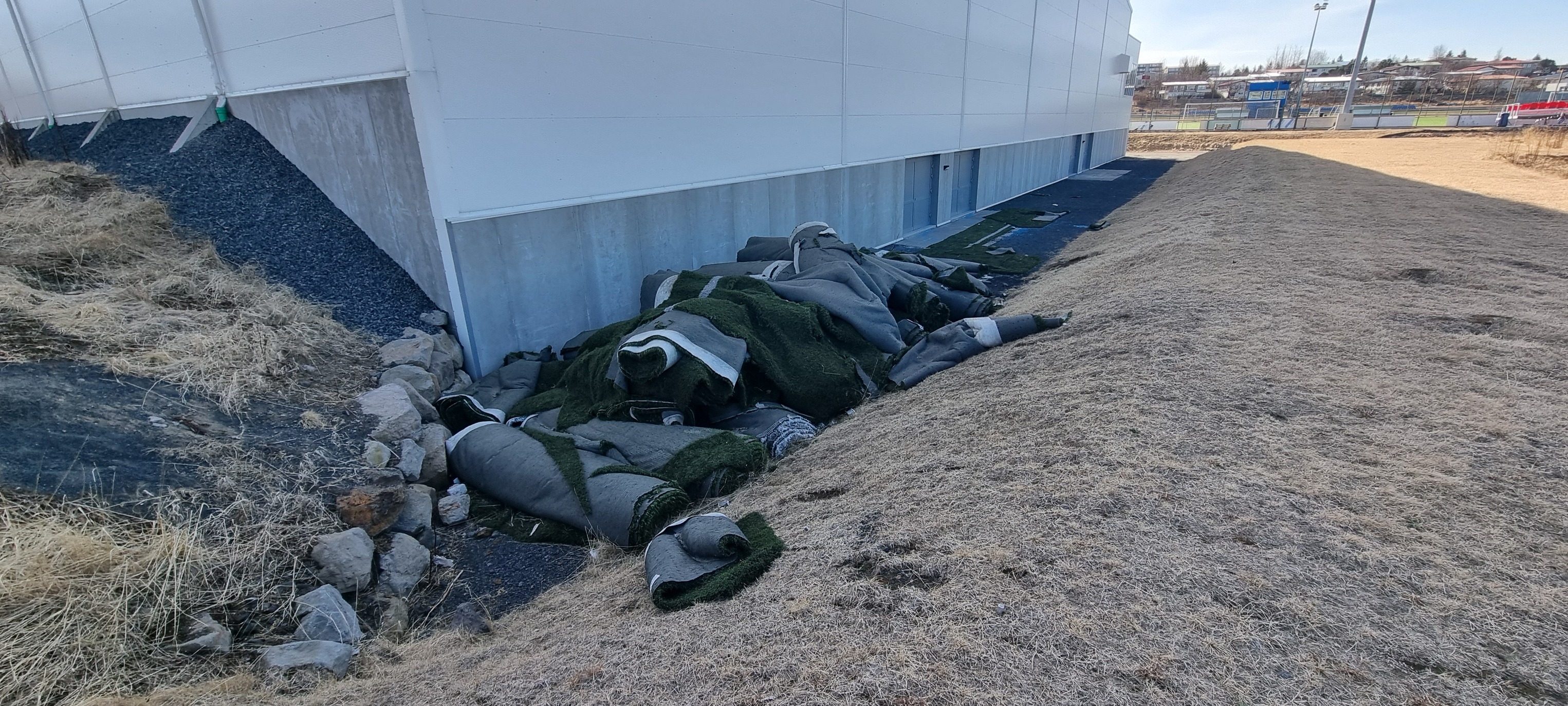 Gervigras og einangrun í haug við vegg knatthúss á ÍR-svæðinu.